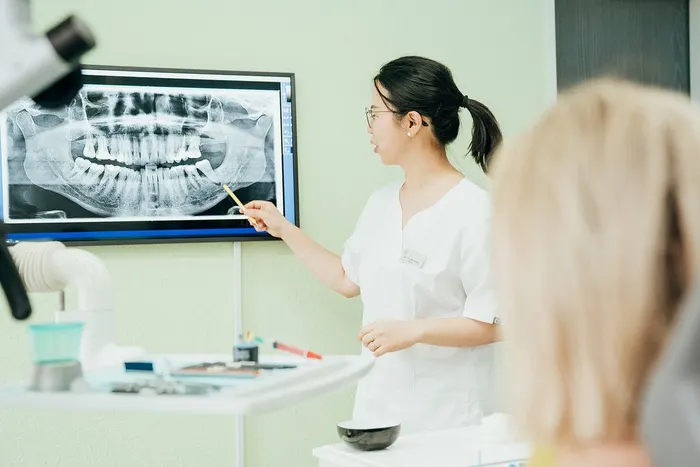 Dr. Jiang erklärt einer Patientin das Röntgenbild am Bildschirm